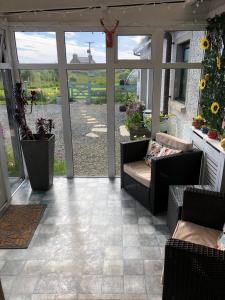 a screened in porch with two chairs and a table at Old School - Exclusive 5 Room private suite in Orkney