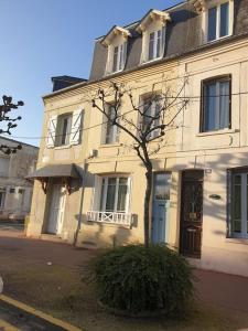uma casa branca com uma árvore em frente em DEAUVILLE Maison plein centre, ideale famille ! em Deauville