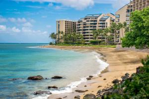a beach in front of some buildings and the ocean at Kahana Villa E409 in Kahana