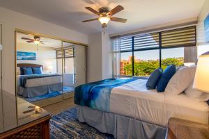 a bedroom with a large bed and a large window at Kahana Villa E409 in Kahana +15 photos