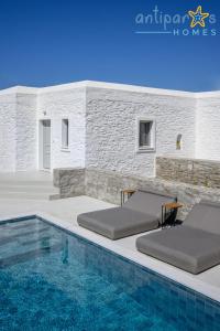 una piscina con due letti accanto a una casa di Antiparos Homes a Città di Antiparo