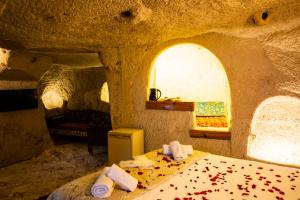 ネヴシェヒルにあるunicorn cave hotelの石造りのベッドルーム1室(ベッド1台付)