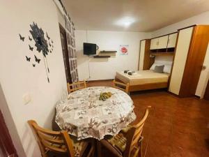 ein Zimmer mit Tisch und Stühlen und ein Schlafzimmer in der Unterkunft Studio 2+2 in Pakoštane