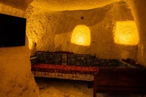 ネヴシェヒルにあるunicorn cave hotelの石窟のベッド1台