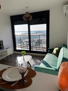 sala de estar con sofá verde y mesa en Apartamento nuevo, centrico y con vista a la bahia en Montevideo