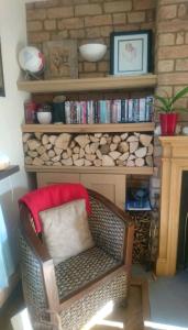 a wicker chair sitting in a living room next to a fireplace at Spring Gardens Retreat And Spa Private hottub,Sauna,Massage in Great Malvern