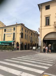 een straat met een zebrapad in een stad met gebouwen bij Hotel Donatello in Padua