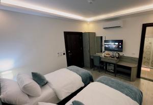 a hotel room with two beds and a desk at La Vie Boutique Hotel in Wadi Musa