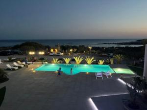 two people playing around a swimming pool at night at Elafonisi Village in Elafonisi