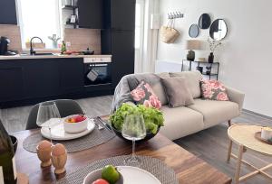 - un salon avec un canapé et une table avec un bol de salade dans l'établissement appartement balnéo-centre ville et parking, à Moulins