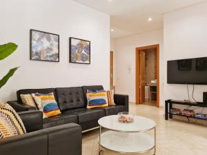 - un salon avec un canapé noir et une table dans l'établissement CASINHA DO MAR - Praia & Centro (500m) - WiFi - AC, à Carvoeiro