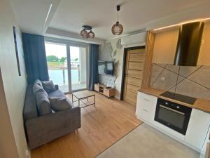 a living room with a couch and a tv at Ogrodowa70 Apartment in Sztutowo