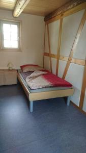 a small bedroom with a bed in a room at Mothsgut - moderne Ferienwohnung auf dem Bauernhof im Erzgebirge in Oelsnitz