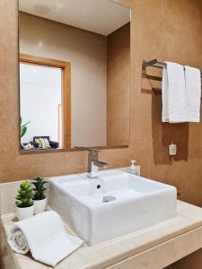 La salle de bains est pourvue d'un lavabo blanc et d'un miroir. dans l'établissement CASINHA DO MAR - Praia & Centro (500m) - WiFi - AC, à Carvoeiro
