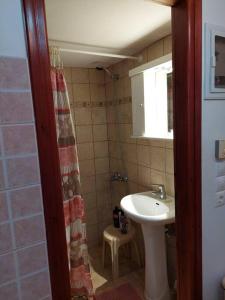 a small bathroom with a sink and a shower at Peaceful and quiet apartment. in Aliki