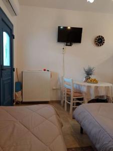 ein Wohnzimmer mit einem Tisch und einem TV an der Wand in der Unterkunft Peaceful and quiet apartment. in Aliki