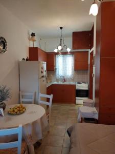 a kitchen with a table and a white refrigerator at Peaceful and quiet apartment. in Aliki
