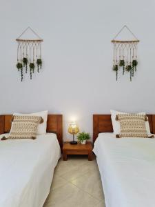 duas camas sentadas uma ao lado da outra num quarto em CASINHA DO MAR - Praia & Centro (500m) - WiFi - AC em Carvoeiro