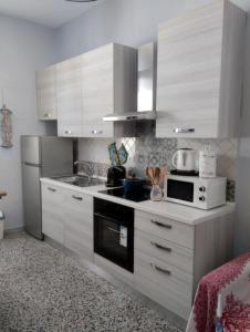 uma cozinha com armários brancos e um forno com placa de fogão em Bilocale per vacanze a Vada em Vada