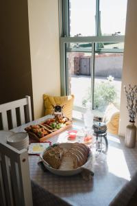 a table with a loaf of bread and a plate of food at Tranquil Rustic Cottage in Dromore