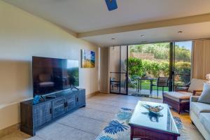 a living room with a large flat screen tv at Kahana Villa E111 in Kahana