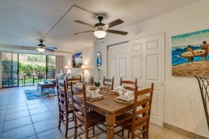 a dining room with a table and chairs and a ceiling fan at Kahana Villa E111 in Kahana