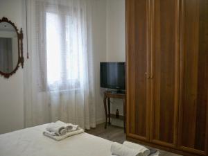 sypialnia z łóżkiem, telewizorem i ręcznikami w obiekcie locazione Mery w Wenecji