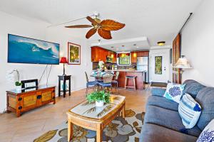 Noelani 115 في Kapalua-West Maui Airport: غرفة معيشة مع أريكة زرقاء وطاولة