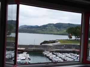 a window view of a marina with boats in the water at ATICO TORRONTERO in Mundaka