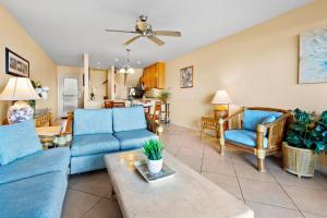 Kahana Sunset E4 في Napili-Honokowai: غرفة معيشة مع أرائك زرقاء وطاولة