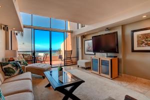 a living room with a couch and a tv at Kahana Villa E706 in Kahana