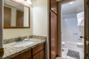 ein Badezimmer mit einem Waschbecken, einem WC und einem Spiegel in der Unterkunft Powder Point Condos by Lespri Property Management in Park City