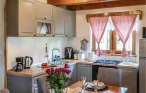 a kitchen with white cabinets and a table with flowers at Lovely Home In Gornje Pazariste in Donje Pazarište