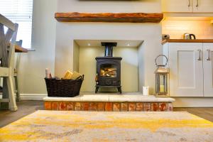 a fireplace in a kitchen with a stove at Clonlum Holiday Cottages in Newry