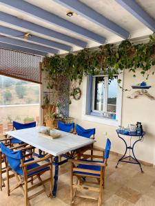 a dining room with a table and blue chairs at Elichrisos Apartment Spetses in Spetses