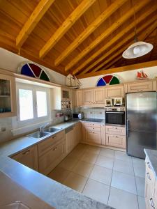 cocina con armarios blancos y techo de madera en Elichrisos Apartment Spetses, en Spetses