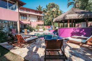 a resort with a pool and chairs and a building at Vila Bardot in Barra do Sahy