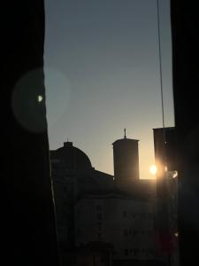 a view of the sun setting over a city at Colliseu Hotel Pousada in Aparecida