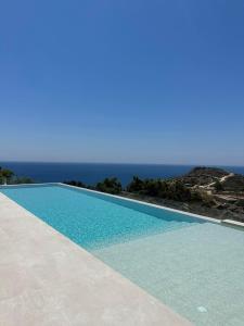 a swimming pool with the ocean in the background at Blue Sky in Ios Chora