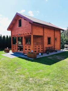 een grote houten hut met een grote tuin bij Domek letniskowy Orzech Rydzewo in Rydzewo