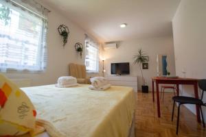 a bedroom with a bed with towels on top of it at Studio Sunlight+ private parking in Novi Sad