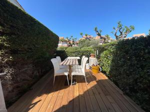 a wooden deck with a table and chairs on it at Appartement * Palavas-les-flots * Piscine in Palavas-les-Flots