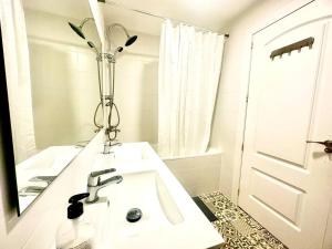 ein weißes Badezimmer mit einem Waschbecken und einem Spiegel in der Unterkunft Con vistas al mar y PortAventura in Salou