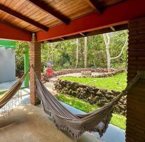 eine Hängematte, die von einer Veranda mit Garten hängt in der Unterkunft Casa para relaxar em Chapada dos Guimarães in Chapada dos Guimarães