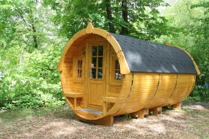 a large wooden hobbit house with a black roof at AZUR Waldcamping Auwaldsee in Ingolstadt