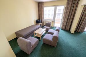 a living room with a couch and chairs and a tv at Rekreačné zariadenie Oliva - Patince in Patince