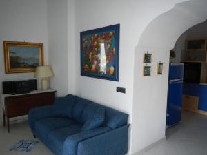 ein Wohnzimmer mit einem blauen Sofa und einem Gemälde an der Wand in der Unterkunft Casa Bouganville in Positano
