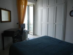 1 dormitorio con cama, escritorio y ventana en Casa Bouganville, en Positano