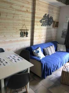 ein Wohnzimmer mit einem blauen Sofa und einem Tisch in der Unterkunft Le Clapotis des Flots in Villers-sur-Mer
