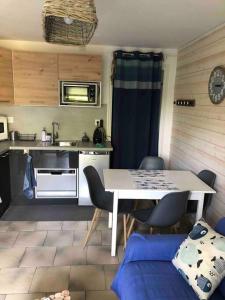 a small kitchen with a table and chairs in a room at Le Clapotis des Flots in Villers-sur-Mer